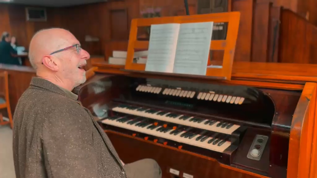 Philip laughing at the organ console in the church